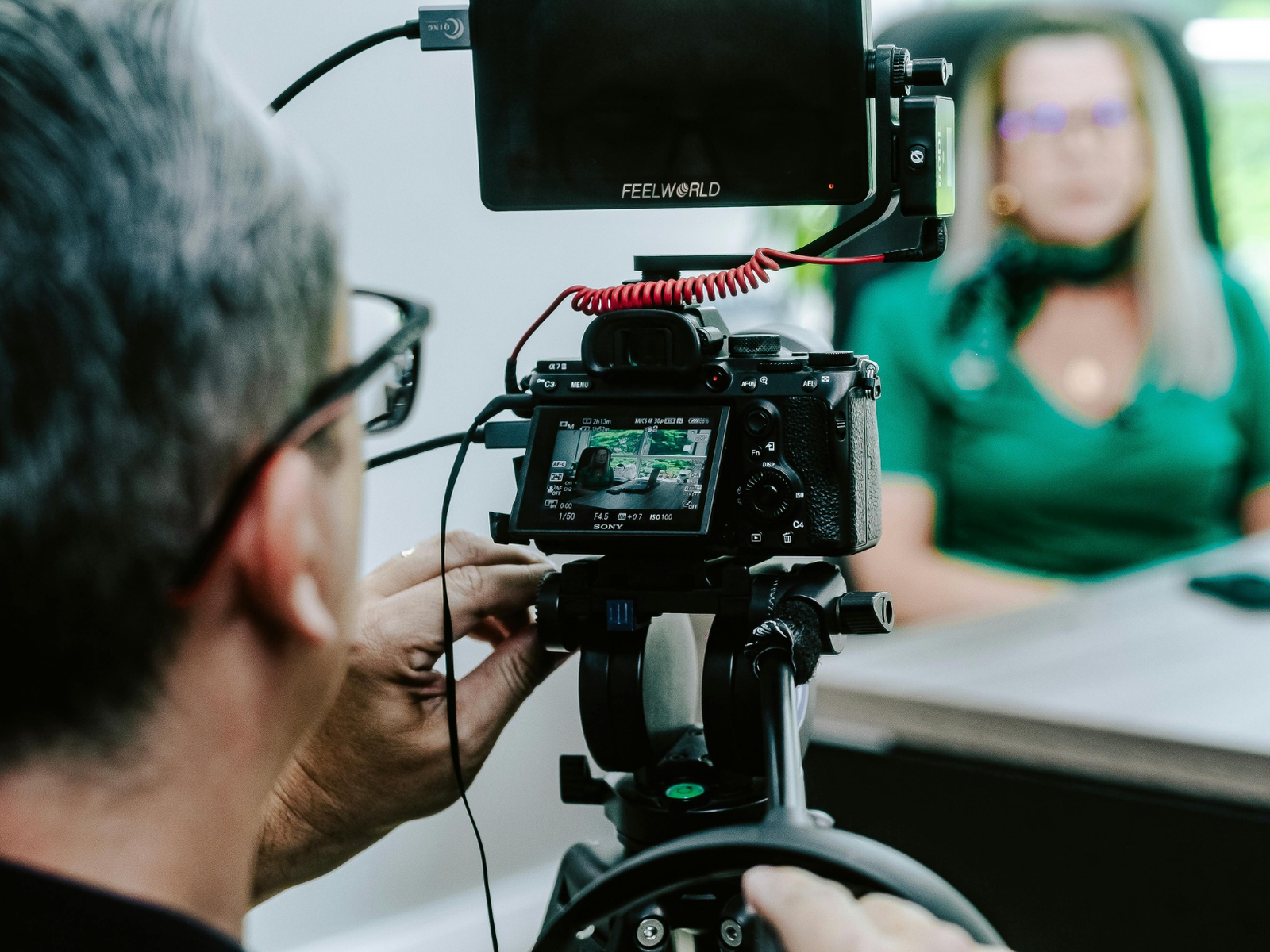 Cameraman filmant un témoignage client en entreprise avec une caméra professionnelle.