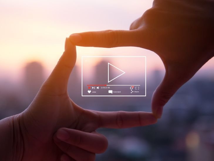 Deux mains encadrant un lecteur vidéo numérique sur fond clair